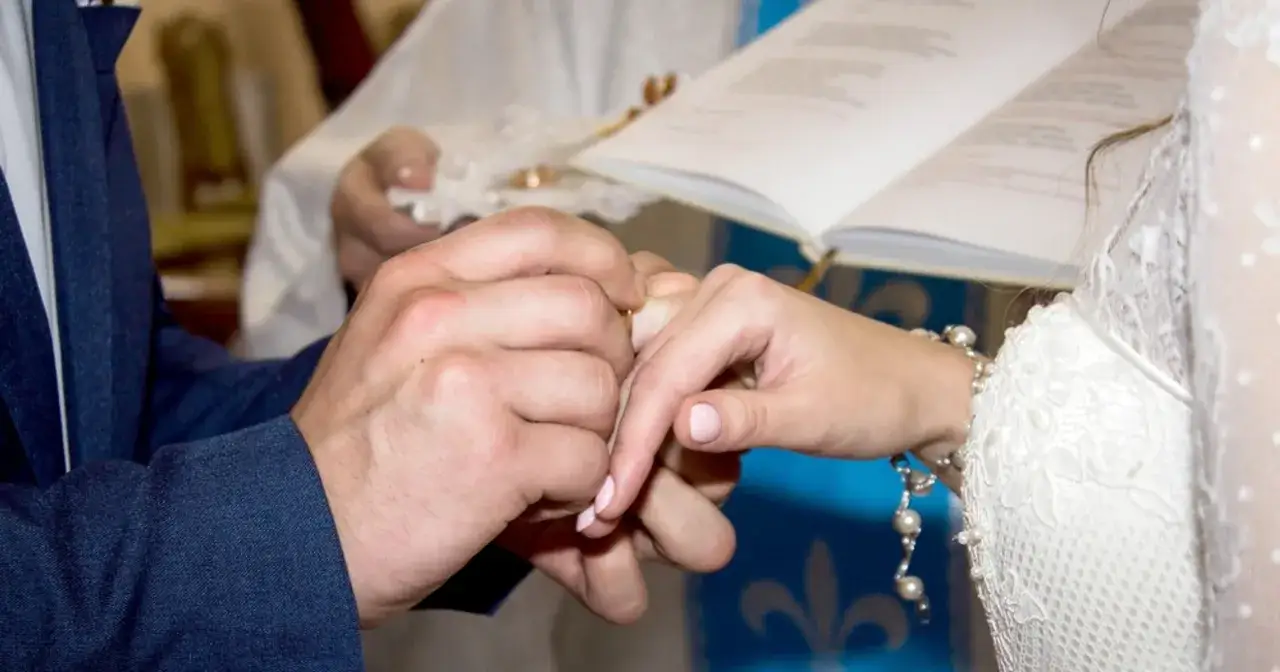 Pan młody zakłada obrączkę na palec panny młodej. Ceremonia ślubna, czy ślub cywilny to grzech? Pytanie to nurtuje wiele par.