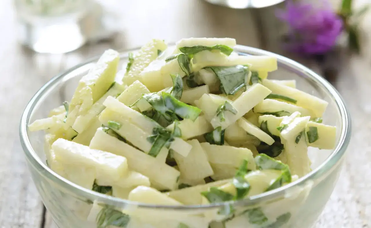 Schneiden Sie Kohlrabi in Streifen für einen schnellen Kohlrabisalat mit frischen Kräutern und einer cremigen Sauce.