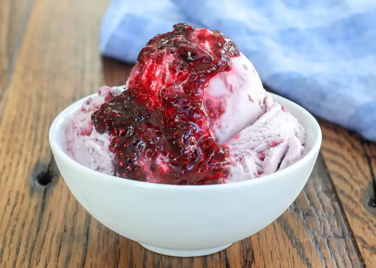Une boule de glace à la vanille nappée d'une compotée de fruits rouges. Parfait avec quoi accompagner une boule de glace pour un dessert gourmand.