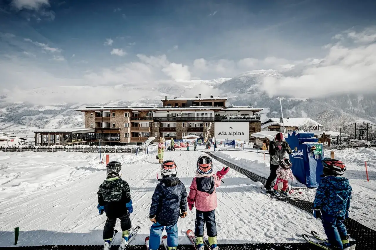 Bambini pronti a sciare al family resort Rainer Sesto, con la neve e le montagne sullo sfondo.