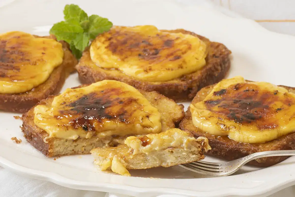 Torrijas de pan con crema y azúcar caramelizado, perfectas para probar recetas de torrijas de pan.
