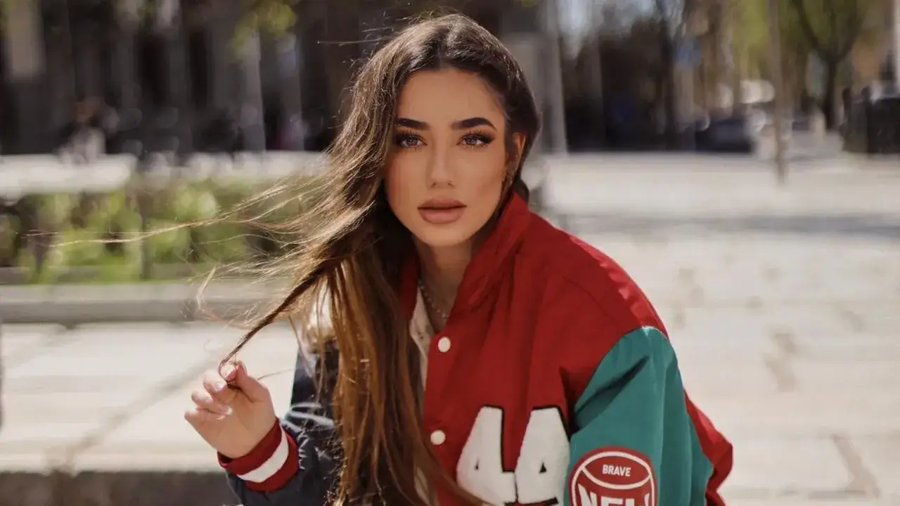 Lola Lolita, con su melena suelta y chaqueta deportiva, posa con mirada intensa.