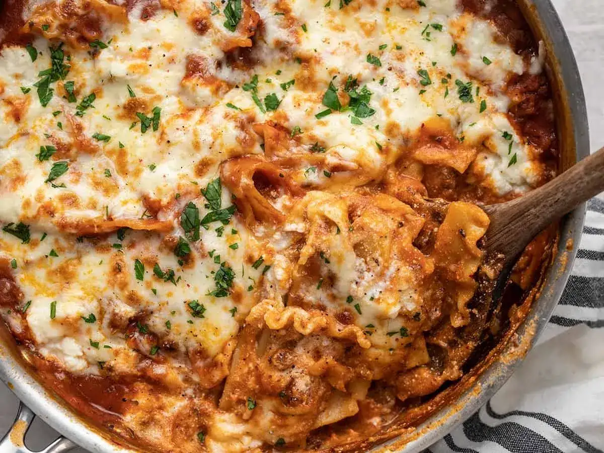 En härlig one pot lasagne med smält ost och färsk persilja, redo att serveras ur pannan.