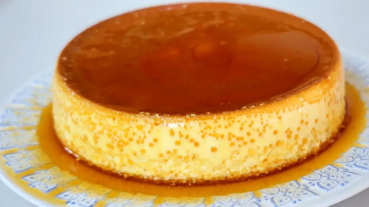 Un delicioso flan de queso, con su caramelo dorado escurriendo por los lados, listo para ser disfrutado.