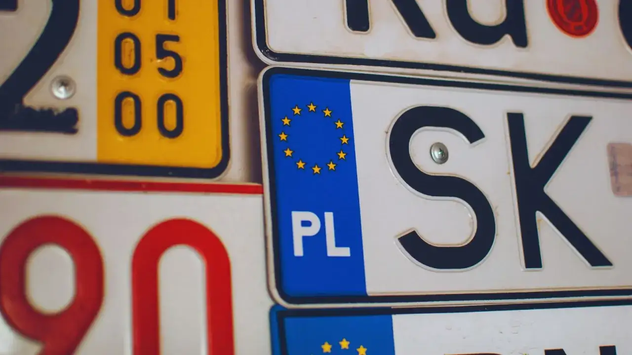 Kolekcja tablic rejestracyjnych z UE. Widoczne PL, SK i numery.