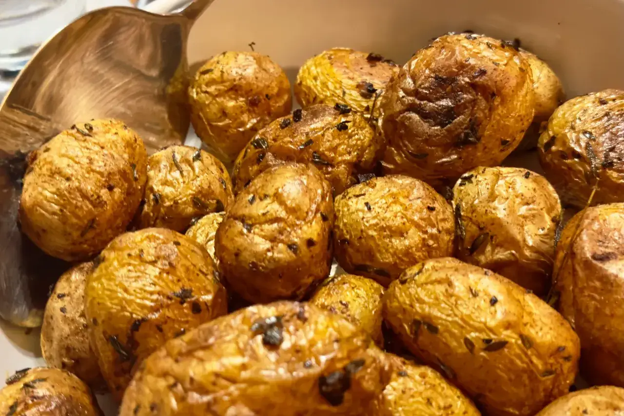 Knusprige, goldbraune Kartoffeln, wie sie f&uuml;r Patatas Bravas typisch sind, mit Kr&auml;utern verfeinert und bereit zum Servieren.