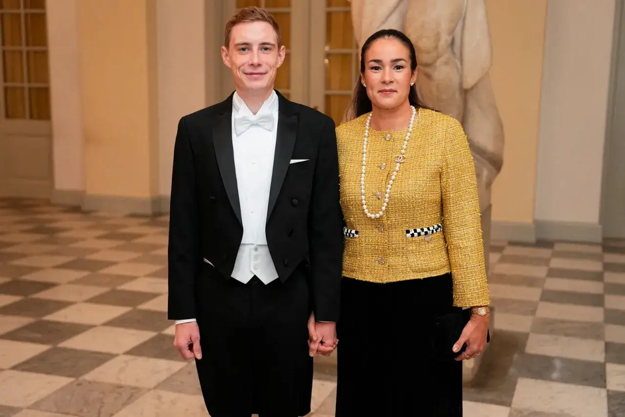 Jonas Vingegaard and his wife, Trine Marie, dressed formally for an event. He wears a tuxedo, and she sports a yellow tweed jacket and pearl necklace.