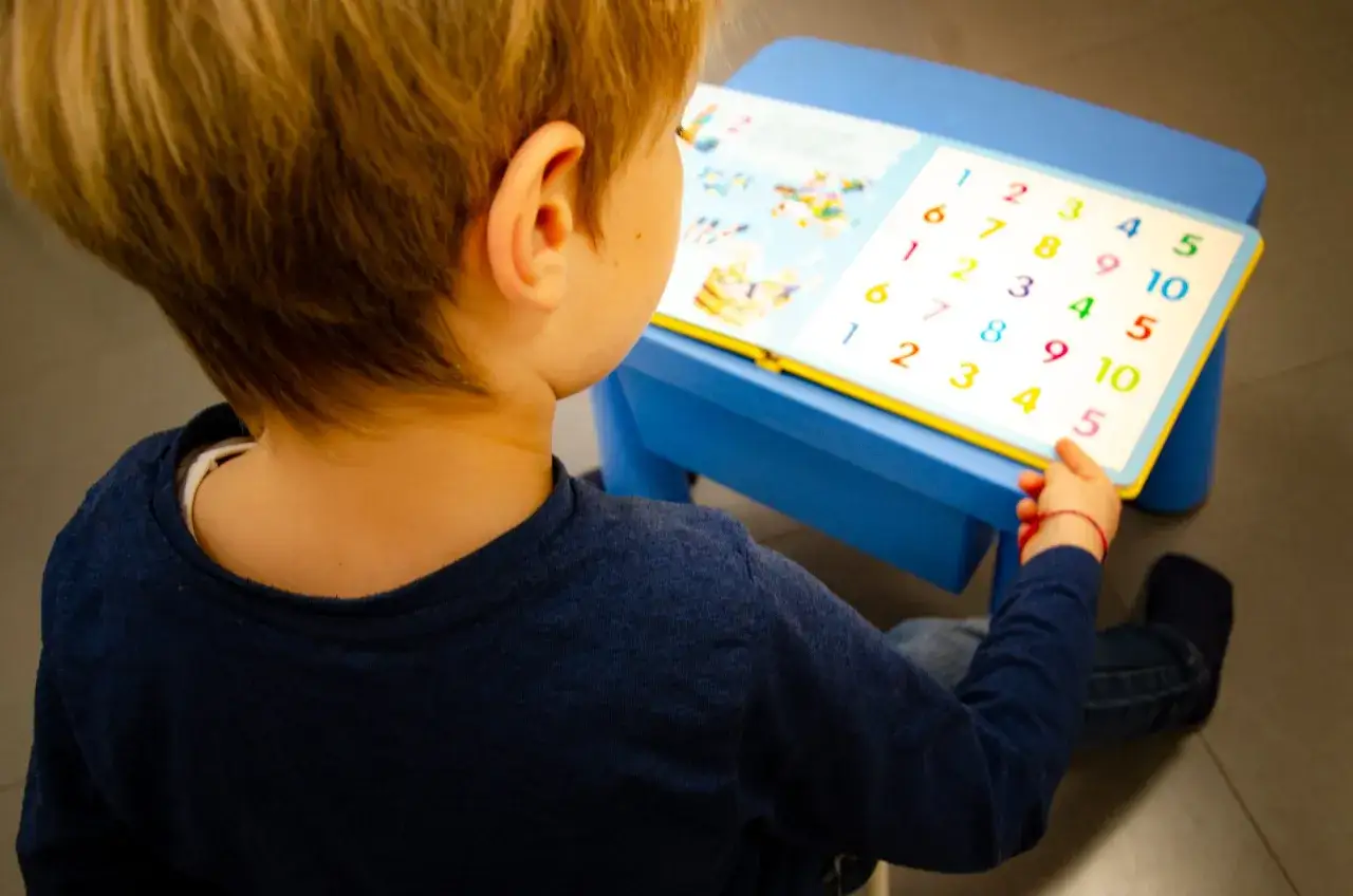 Bambino con libro sui numeri, parte di un percorso di test logopedia bambini.