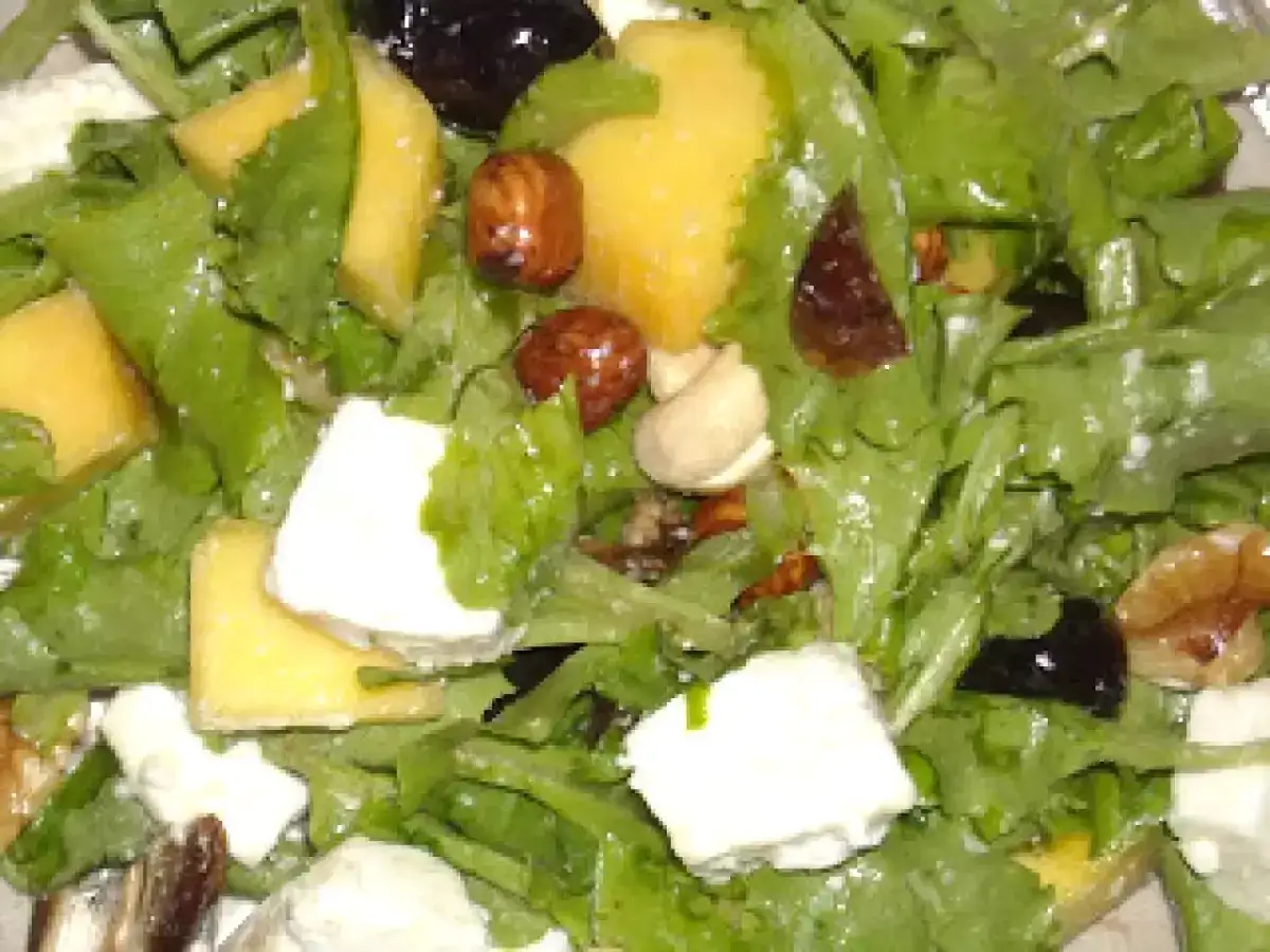 Insalata fresca con cubetti di mango, formaggio, noci e olive nere. Un mix di sapori e consistenze per un piatto leggero e gustoso.