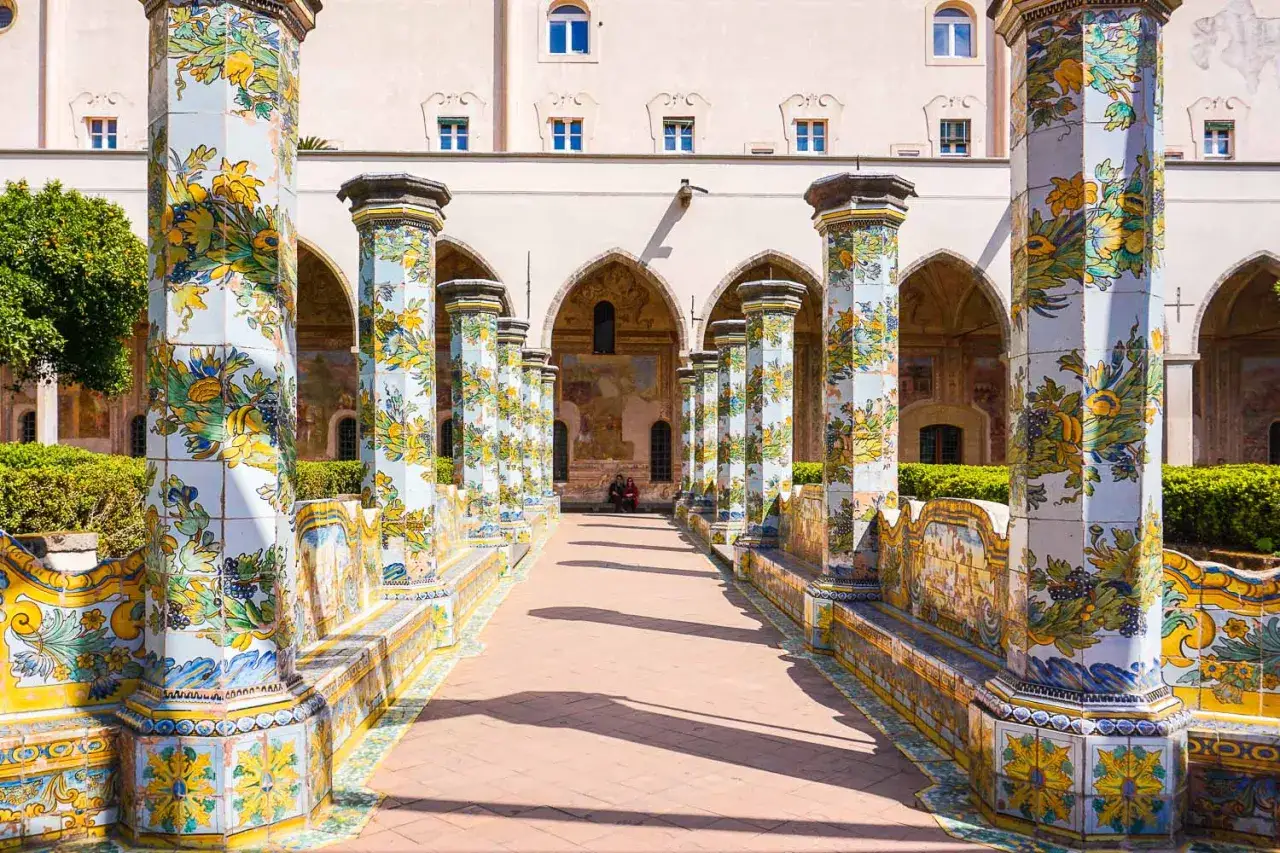 Chiostro maiolicato con colonne decorate, un luogo incantevole da scoprire tra le cose da vedere a Napoli centro.