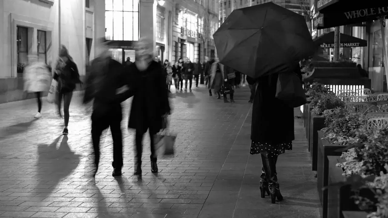 Nocna fotografia uliczna, rozmyte postacie pod parasolem i w tłumie. Czy to legalne?