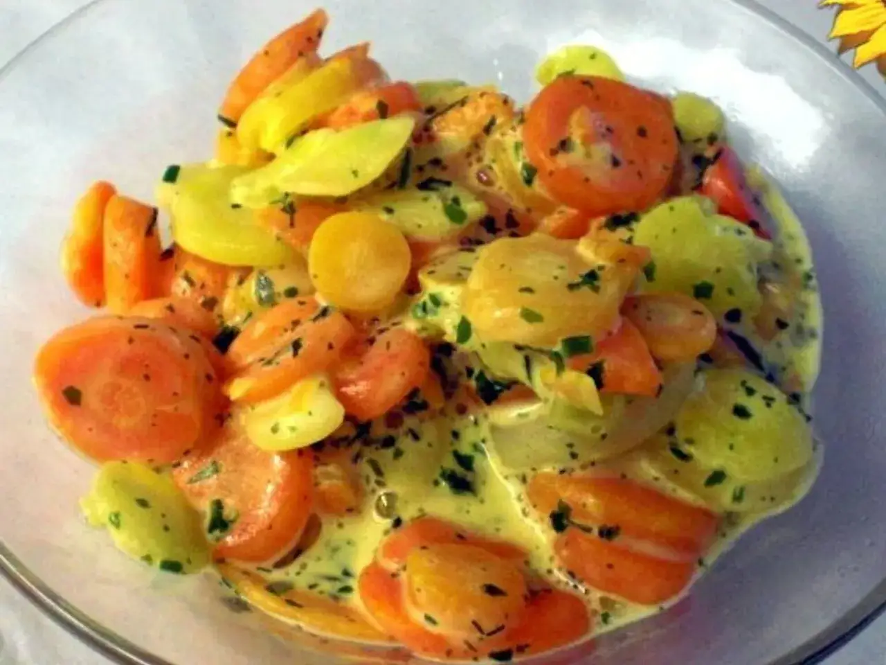 Bunte Karotten in cremiger Sauce, garniert mit Kräutern. Ein farbenfroher Genuss!