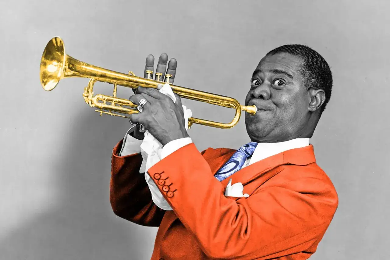 Satchmo, przydomek Louisa Armstronga, gra na złotej trąbce w pomarańczowej marynarce.