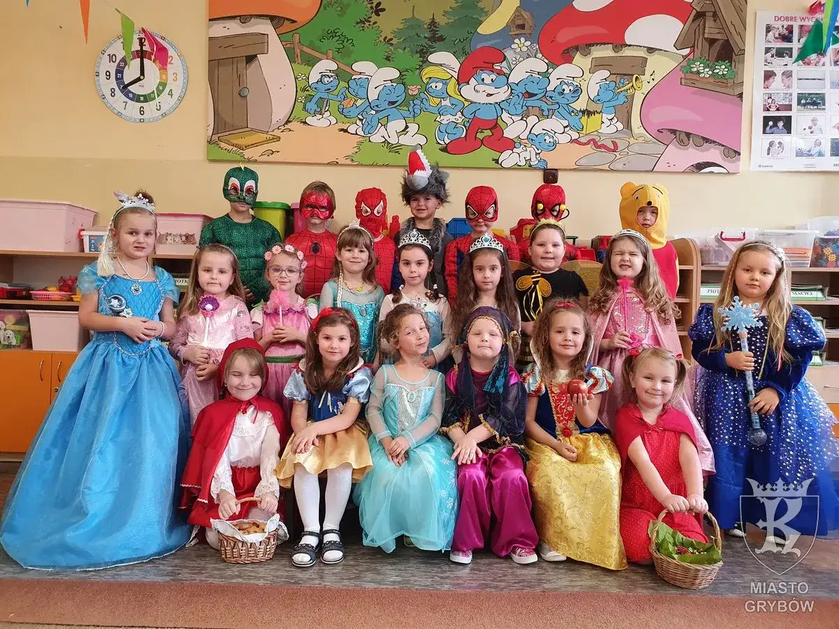 Dzień postaci z bajek pomysły: dzieci w strojach księżniczek, Spider-Mana, Kubusia Puchatka i Smerfów pozują do zdjęcia.