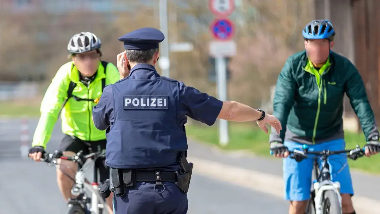 Polizist stoppt Radfahrer. Betrunken Fahrrad fahren kann eine Strafe nach sich ziehen.