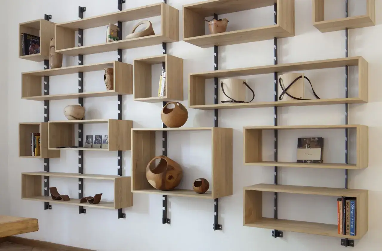 Scaffali in legno componibili, perfetti per progetti fai da te. Espongono libri, vasi e oggetti decorativi in un design moderno.