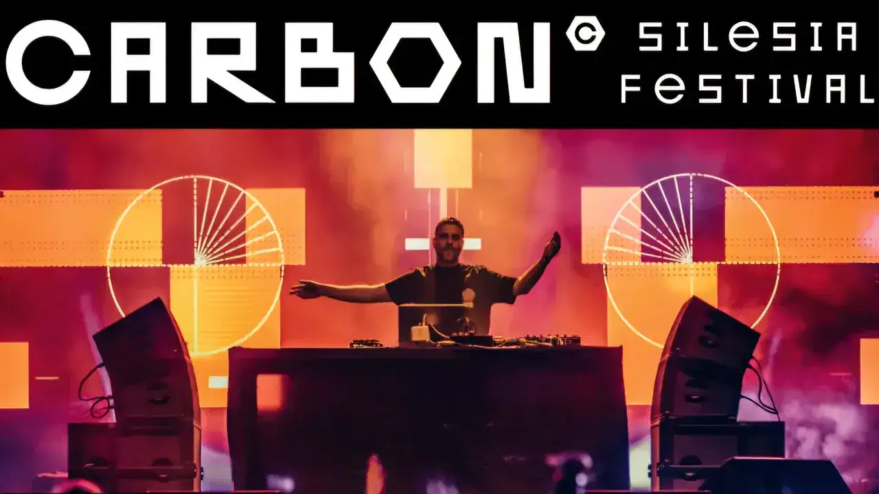 DJ na scenie podczas festiwalu Carbon Silesia, otoczony światłami i głośnikami.