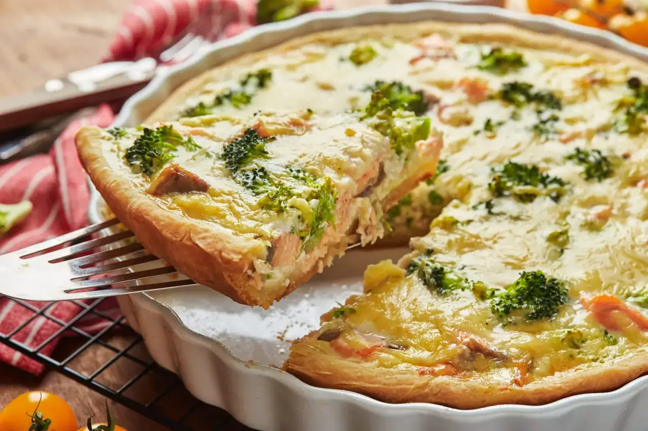 Quiche saumon et brocolis sur pâte brisée allégée weight watchers. Une part est servie sur une fourchette.