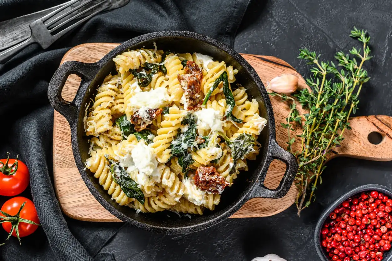 Szybki obiad z makaronem fusilli, szpinakiem, suszonymi pomidorami i fetą. Idealne danie, gdy brakuje czasu na gotowanie.