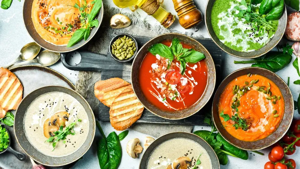 Verschiedene Sch&uuml;sseln mit Suppen-Toppings wie frischen Kr&auml;utern, Croutons und ger&ouml;steten Kernen