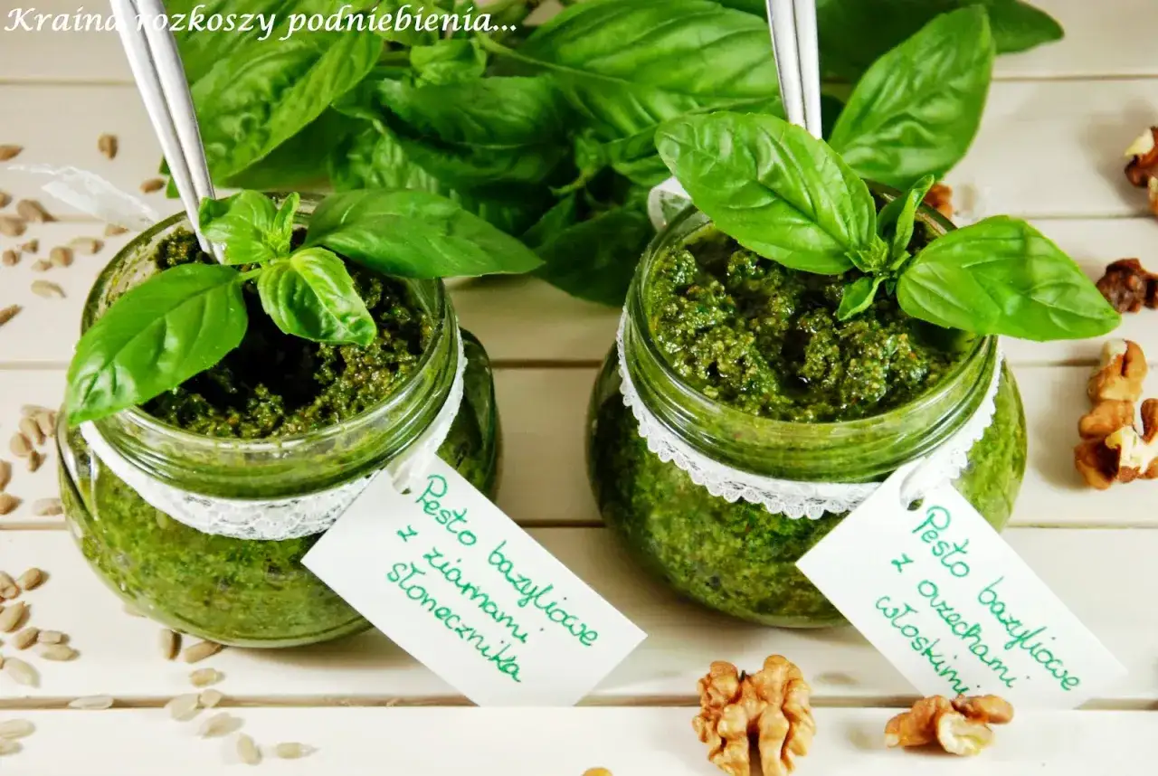 Dwa słoiczki pesto bazyliowego: jedno z orzechami włoskimi, drugie z nasionami słonecznika. Idealne jakie orzechy do pesto.