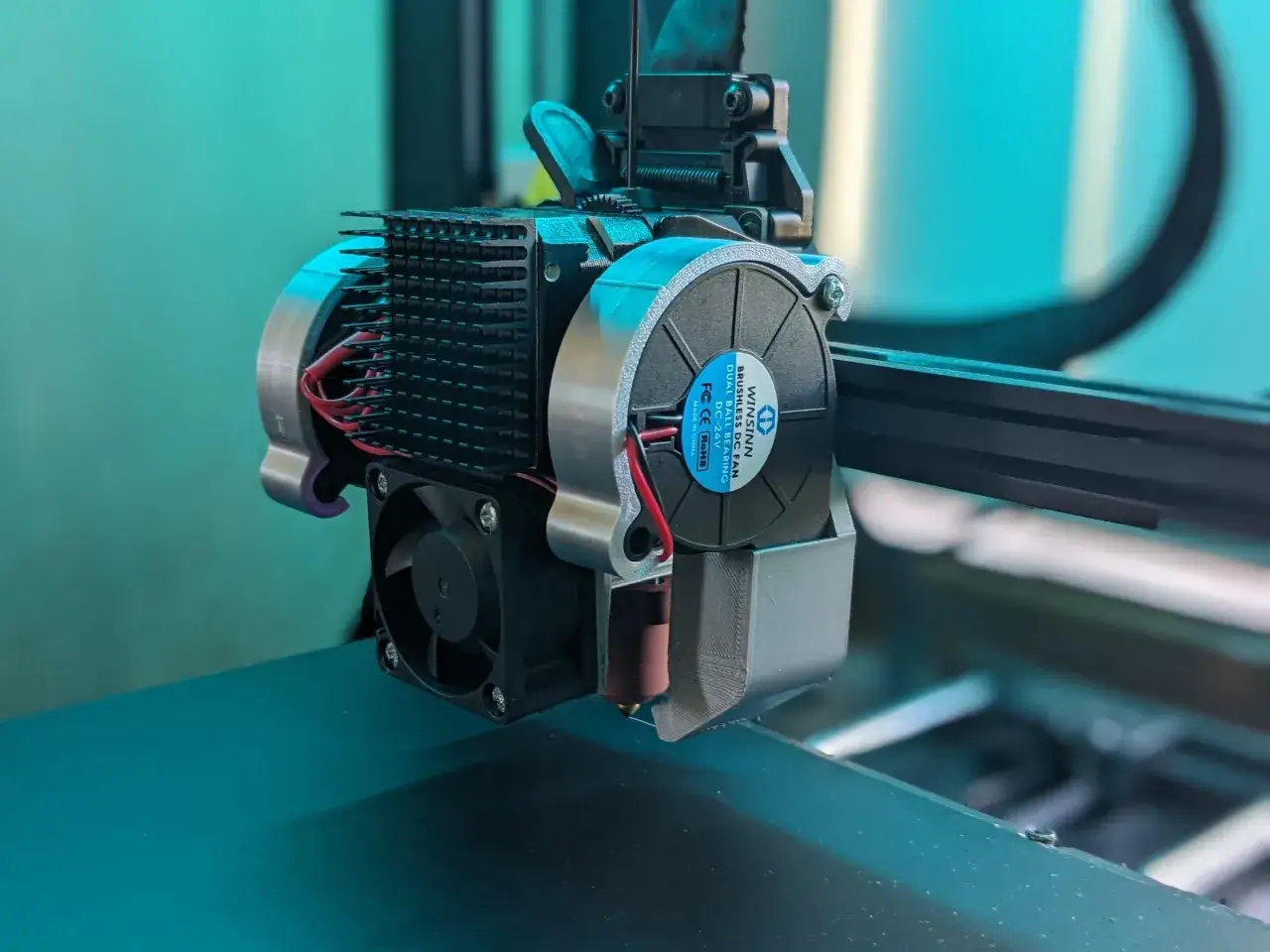 Ulepszony hotend drukarki Ender 3 z nowym wentylatorem i radiatorem. Te modyfikacje poprawiają chłodzenie i jakość druku.