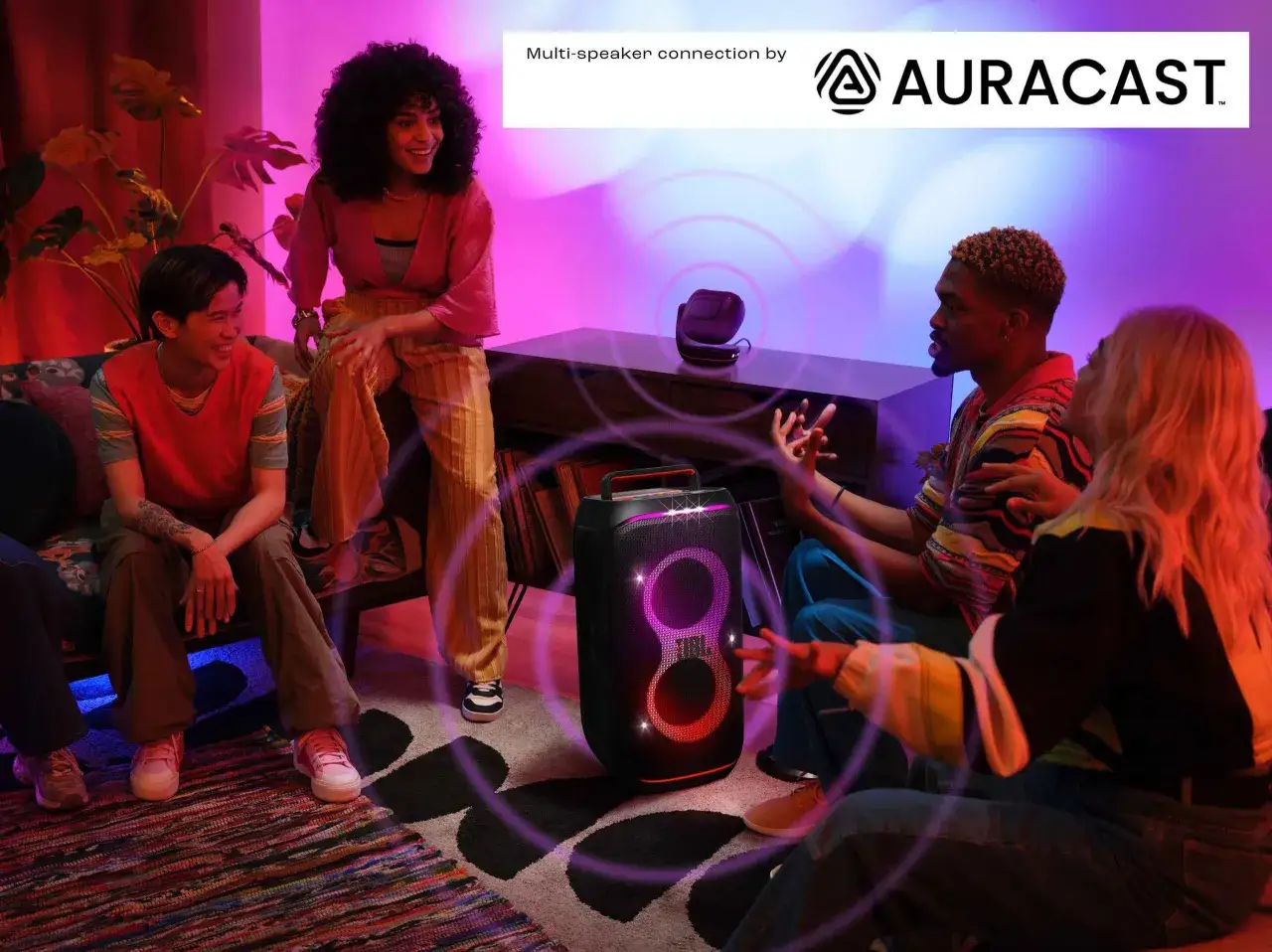 Des amis profitent de la musique avec un haut-parleur JBL. La technologie Auracast permet de connecter JBL ensemble pour une expérience sonore immersive.