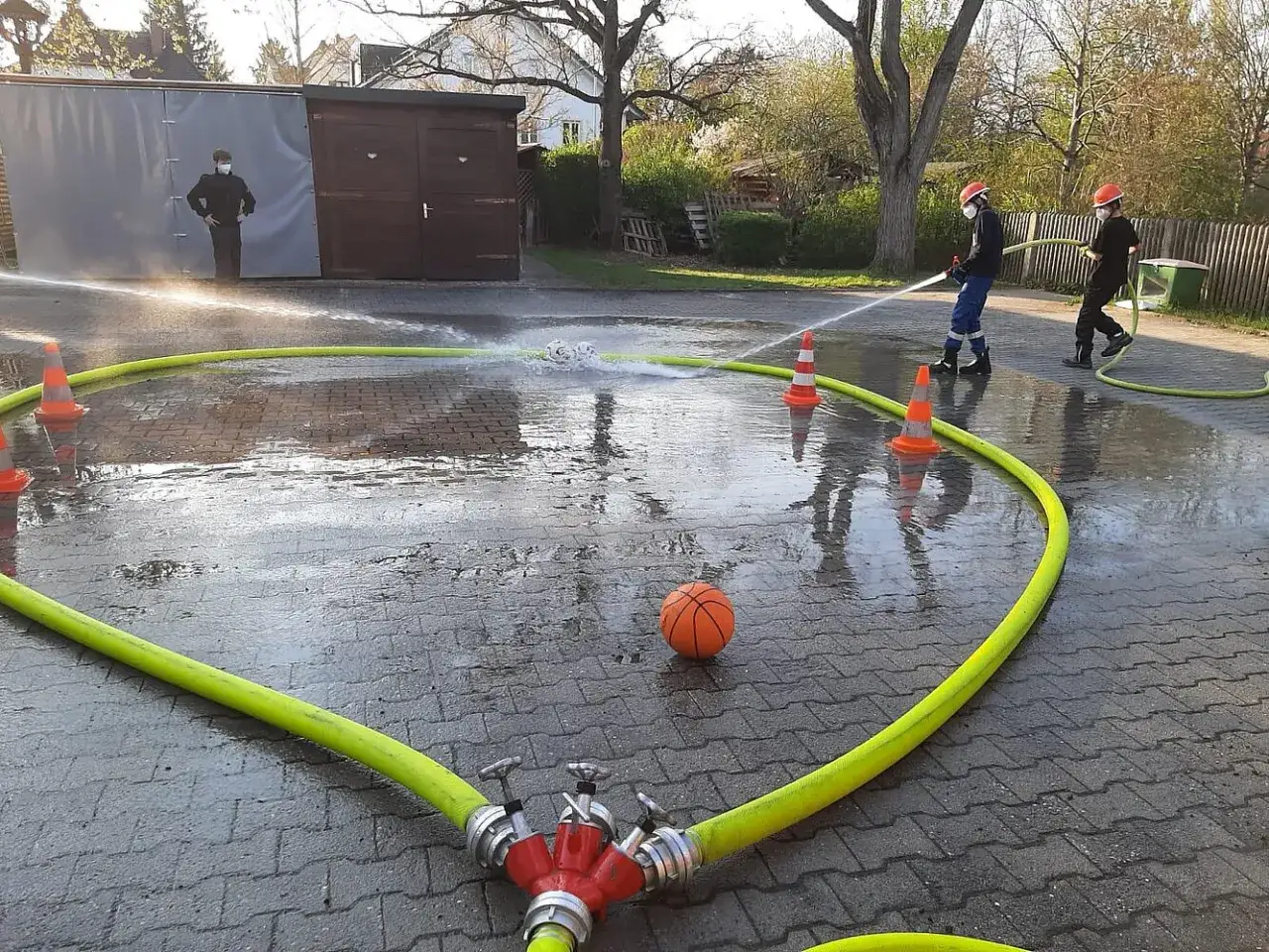 Jugendfeuerwehr &uuml;bt praktische Ausbildungsideen: Wasser marsch! Ein Basketball dient als Ziel.