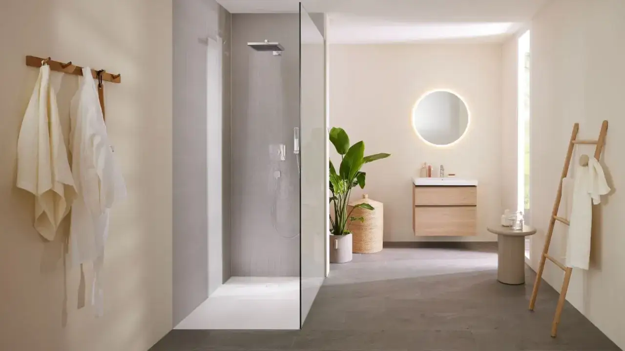 Salle de bain moderne avec douche de sol, lavabo suspendu, miroir lumineux et porte-serviettes en &eacute;chelle.