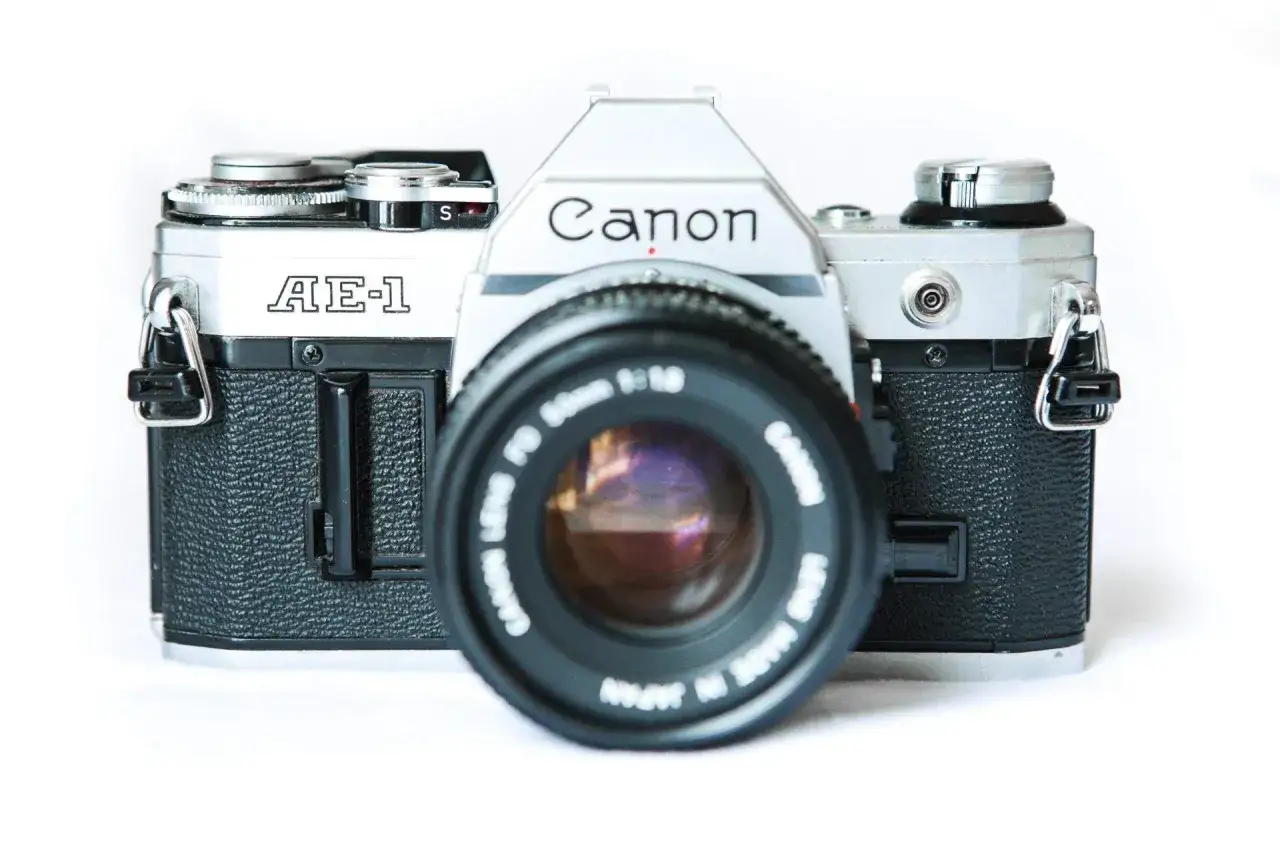 The Canon AE-1, a beloved best canon 35mm film camera, with its iconic silver body and black textured grip, is ready to capture timeless moments.