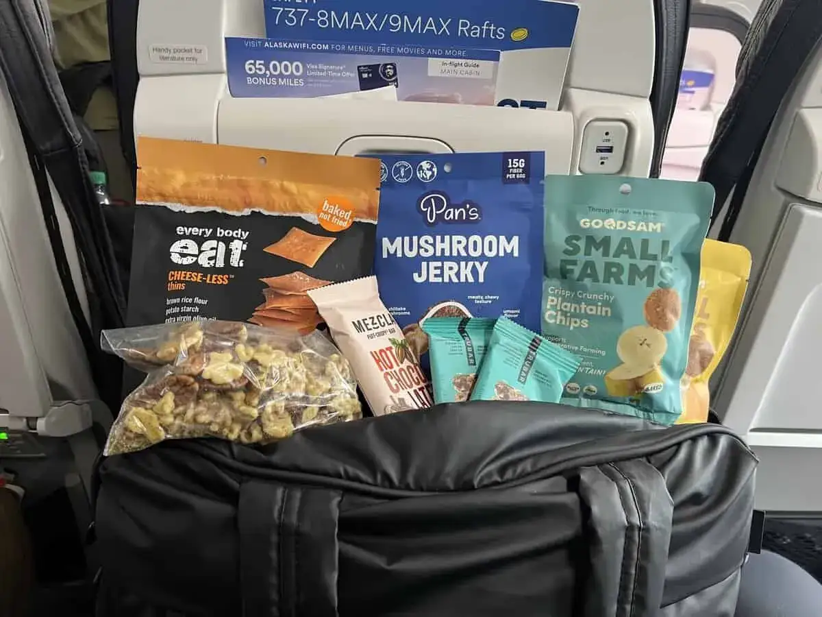 Snacks für das Essen im Flugzeug: Käse-lose Cracker, Pilz-Jerky, Plantain-Chips und Nüsse.