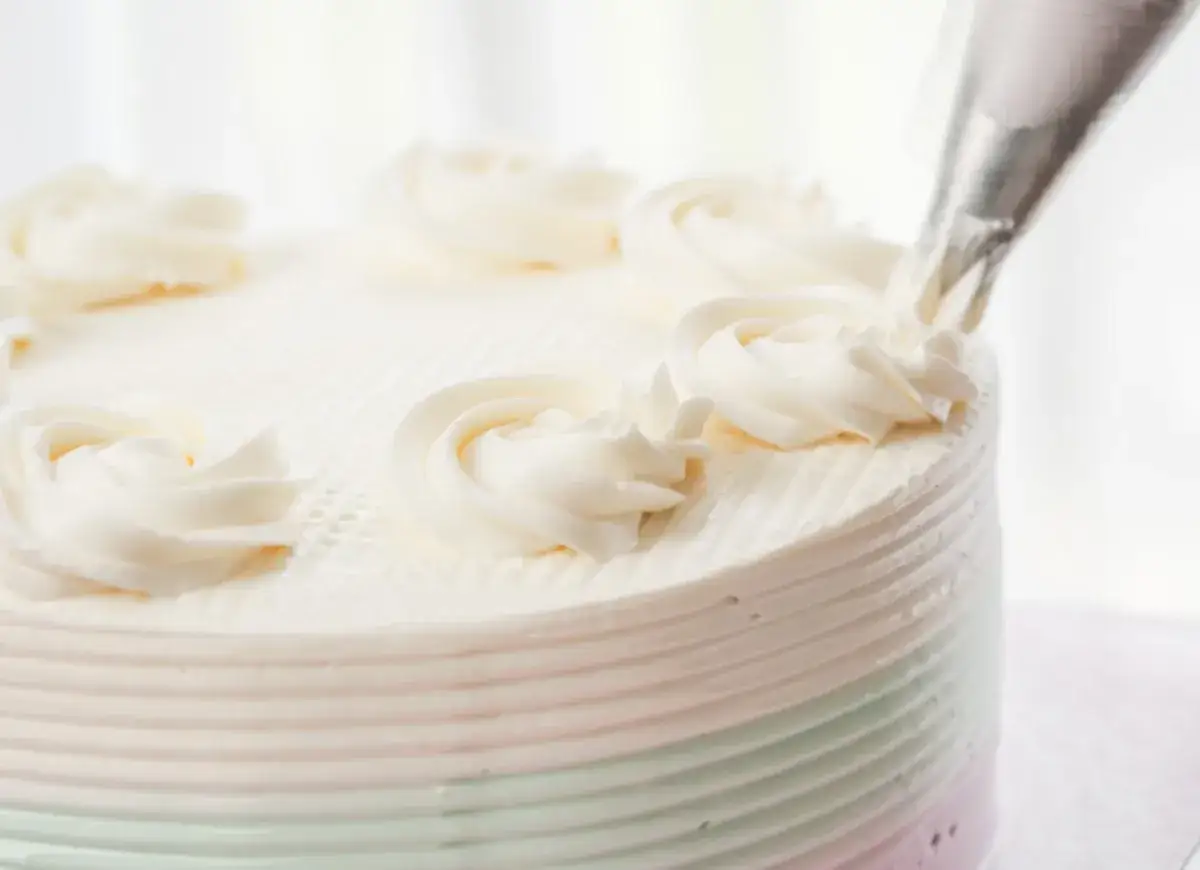 Dekorowanie tortu kremem na bazie śmietanki i mascarpone. Krem maślany jest równie pyszny, ale ten wygląda lekko i puszysto.