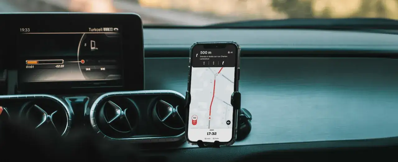 Wohnmobil in malerischer Landschaft mit Smartphone-Navigation im Vordergrund