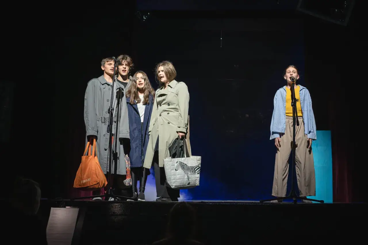 Młodzi aktorzy na scenie, przygotowujący się do spektaklu. To teatr dla młodzieży, gdzie młodość spotyka się ze sztuką.