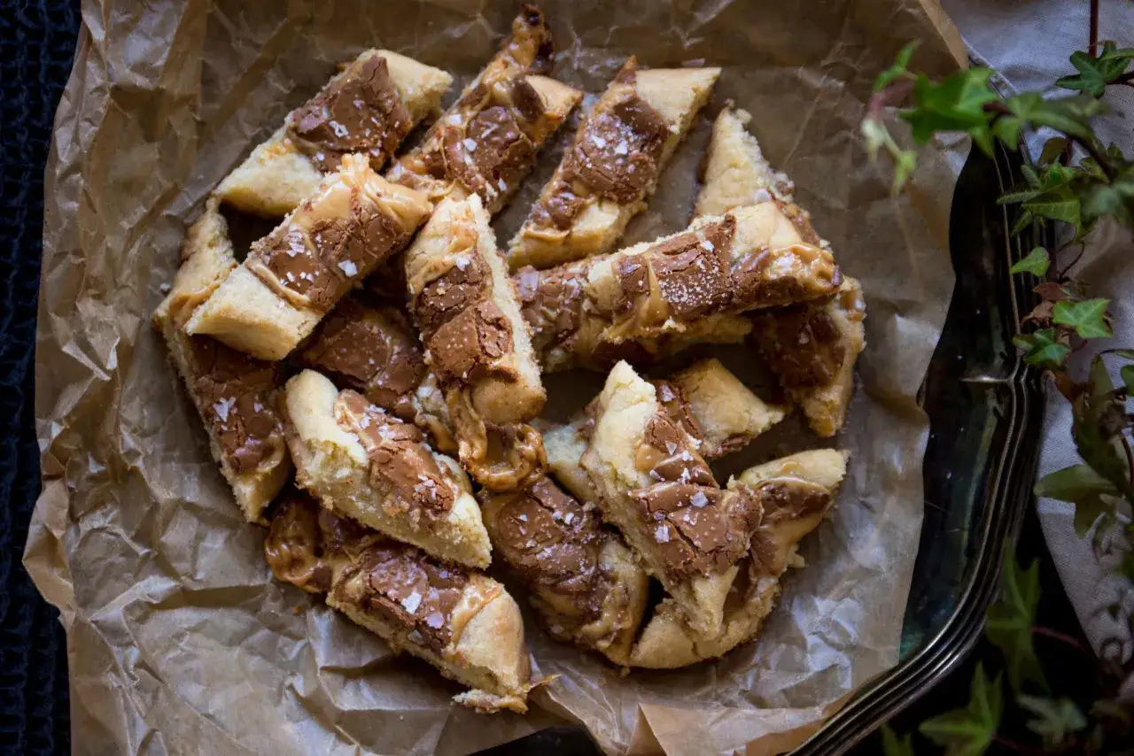 En hög med hembakade kolasnittar med Dumle, strösslade med flingsalt. Perfekt för fikat!