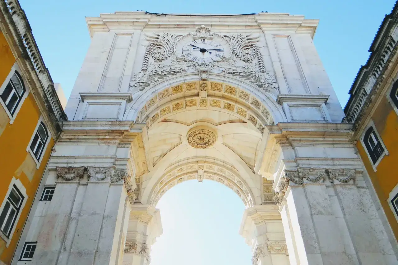 Der Arco da Rua Augusta in Lissabon, ein imposanter Triumphbogen mit einer Uhr, ragt majest&auml;tisch in den blauen Himmel.