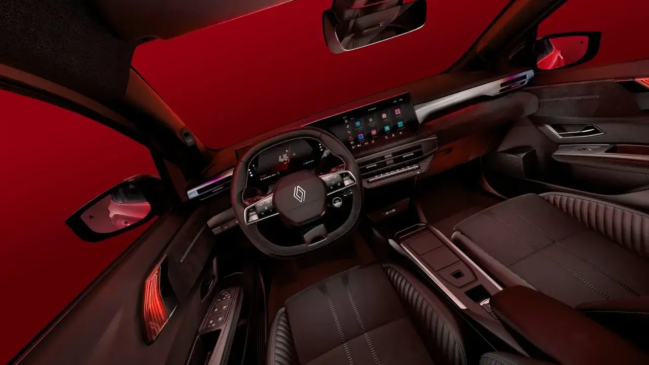 Interiörbild av en mörk, lyxig Renault Clio 2026 med digital instrumentpanel, stor pekskärm och bekväma säten.