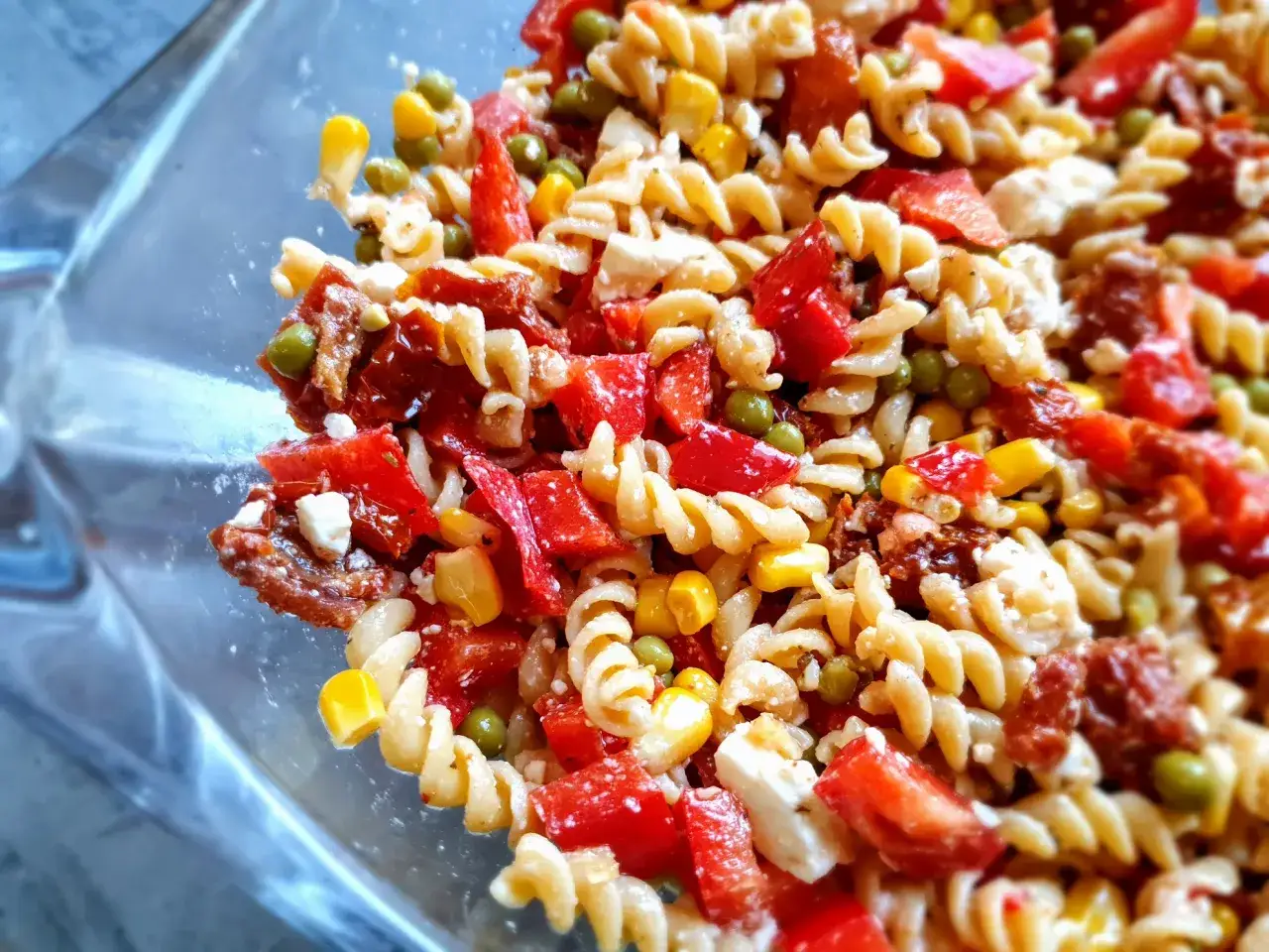 Kolorowa sałatka z makaronem chińskim, papryką, kukurydzą, groszkiem i serem feta.