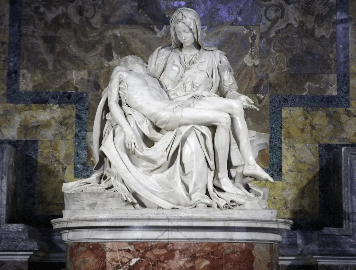 Pieta Michała Anioła: Matka Boska trzyma na kolanach martwe ciało Chrystusa. Marmurowa rzeźba zachwyca realizmem i emocjami.