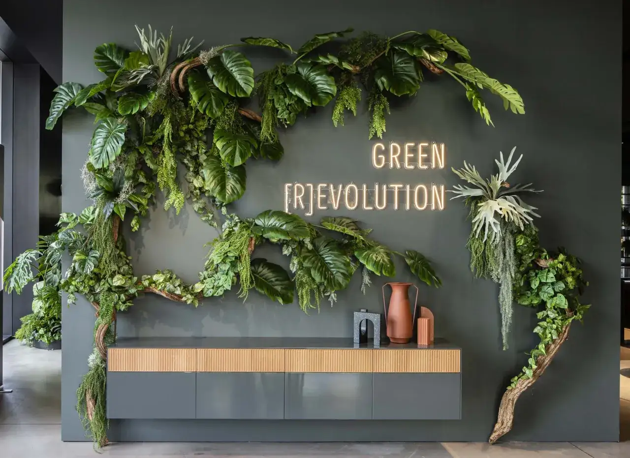Un'installazione verde con piante lussureggianti e neon che recita 