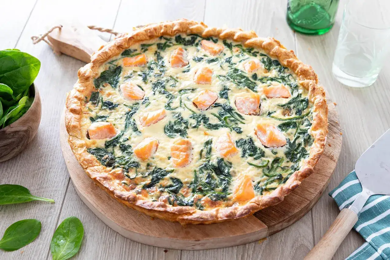 Une d&eacute;licieuse quiche saumon &eacute;pinard frais, garnie de morceaux de saumon rose et d'&eacute;pinards verts, sur une p&acirc;te dor&eacute;e.