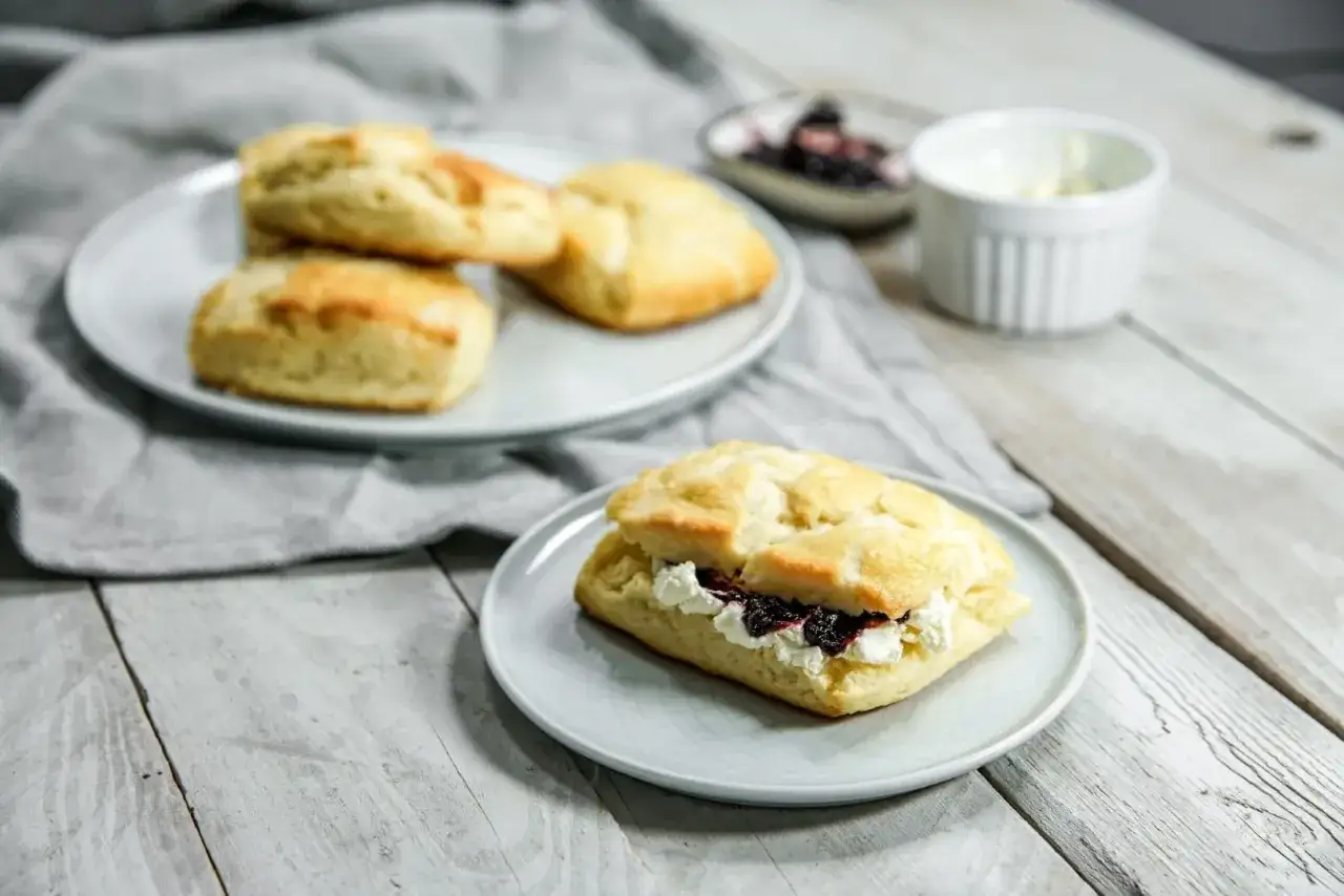 Frisch gebackene Scones, der Teig goldbraun und luftig, mit Marmelade und Clotted Cream gefüllt. Ein Genuss!