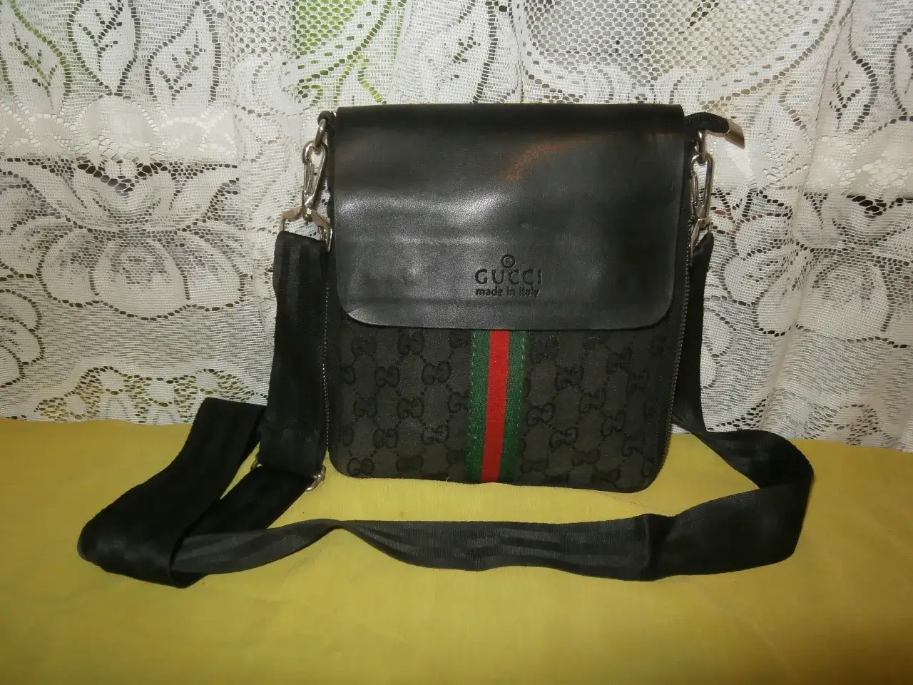 Oryginalna torebka Gucci z czarnej skóry i materiału z monogramem GG, ozdobiona paskiem w kolorach zieleni i czerwieni.