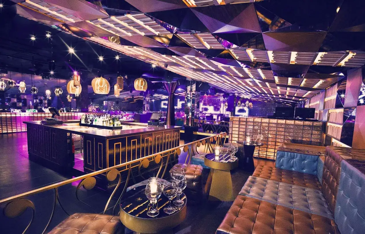 Interno di una discoteca a Barcellona, su 5 piani, con bancone bar, divani in pelle e soffitto a specchi.