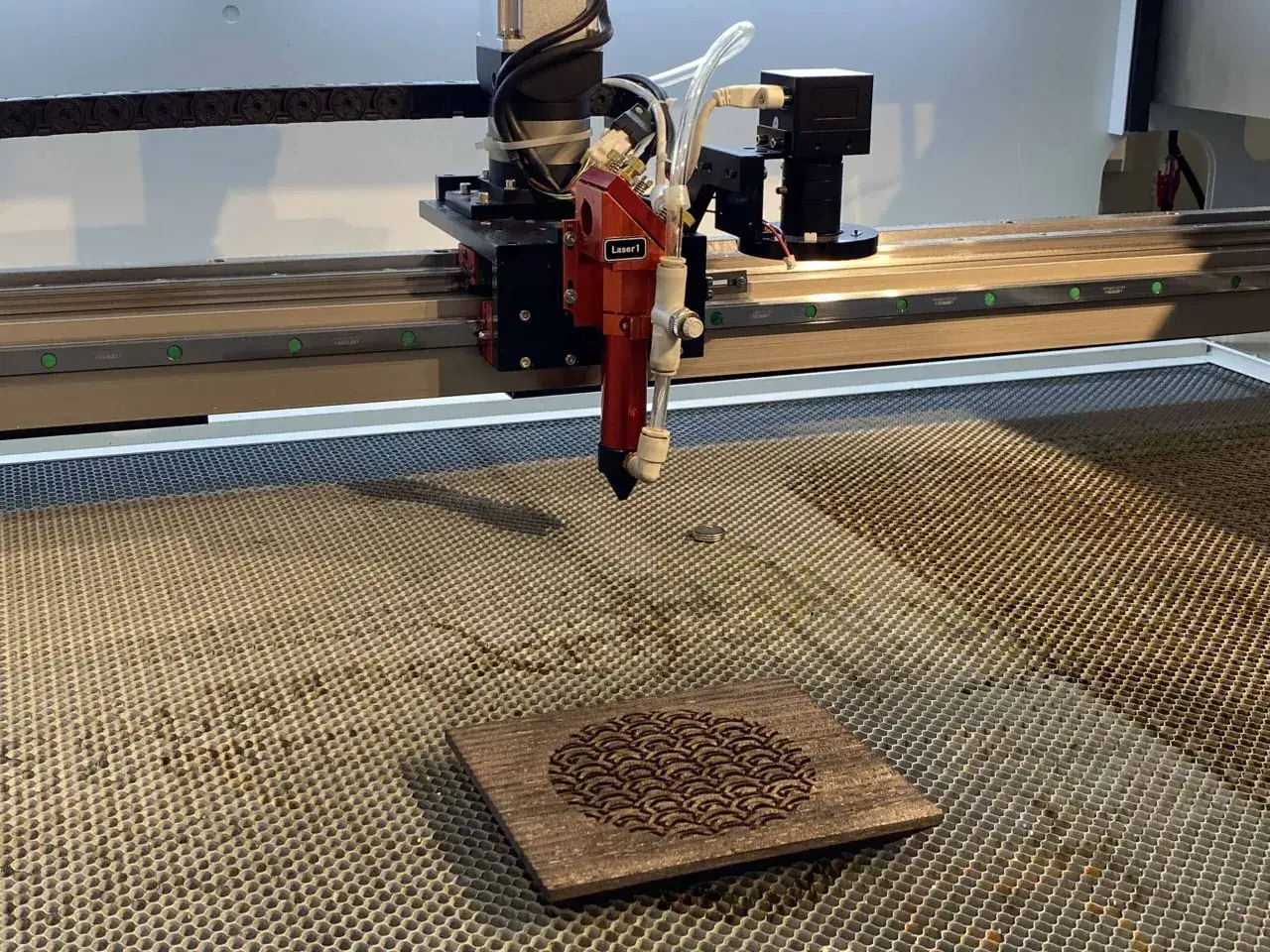 Grawerowanie w drewnie za pomocą lasera. Precyzyjne narzędzie tworzy na drewnianej desce wzór przypominający fale.