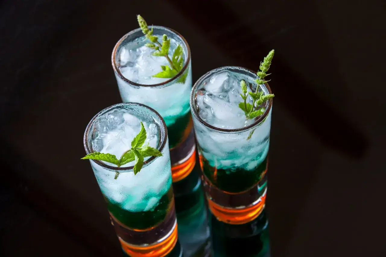 Trzy warstwowe shoty Kamikaze z miętą, zamiast blue curacao, prezentują się kusząco.