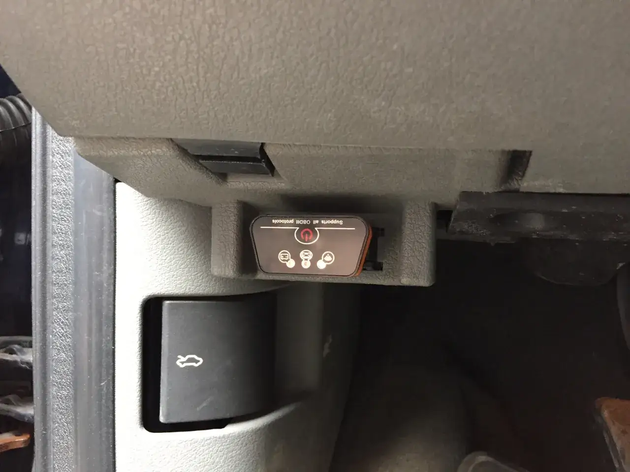 Podłączony skaner OBDII pod deską rozdzielczą. Czas sprawdzić kod błędu i naprawić auto.