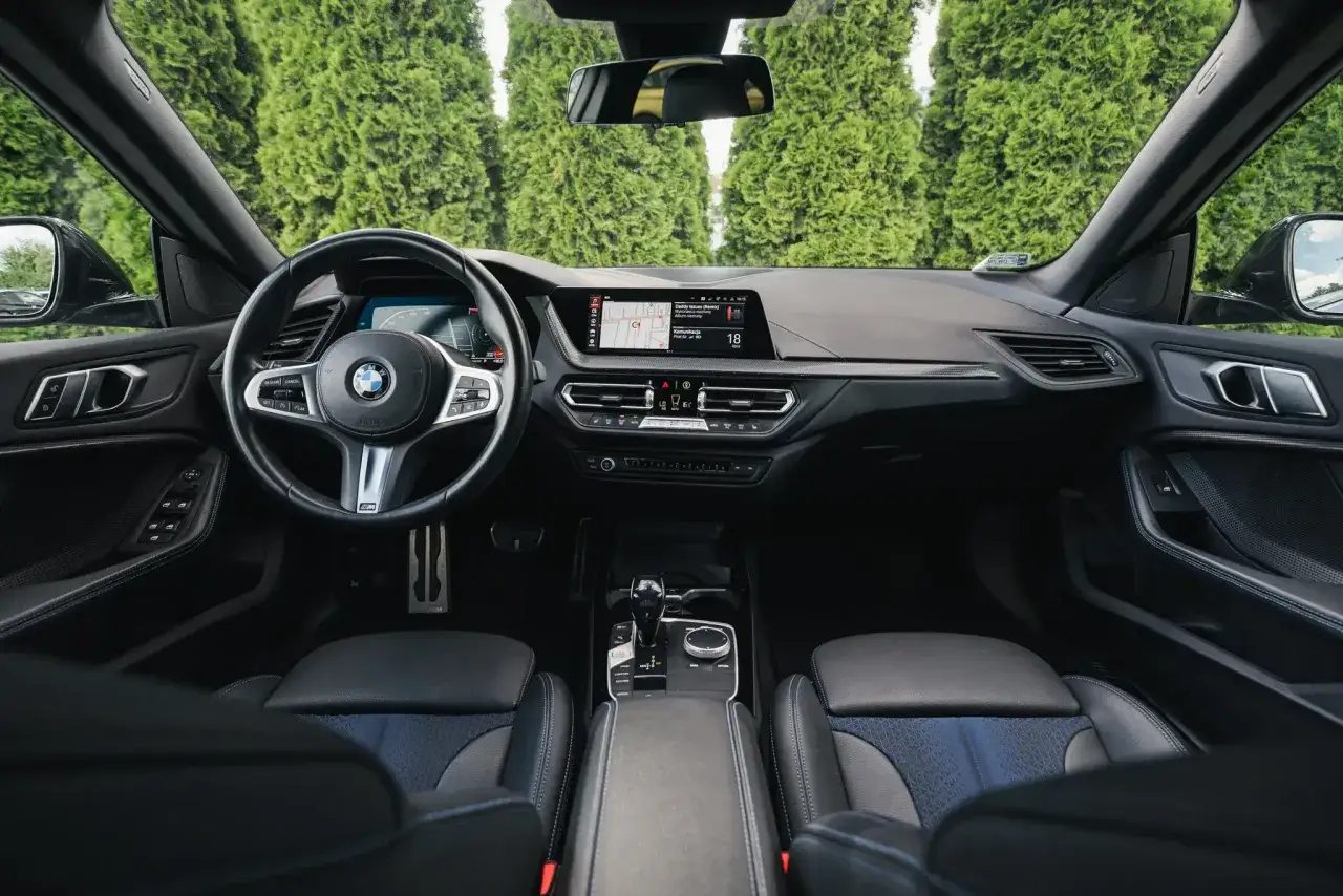 Wnętrze BMW 218i z nowoczesnym kokpitem i ekranem multimedialnym.