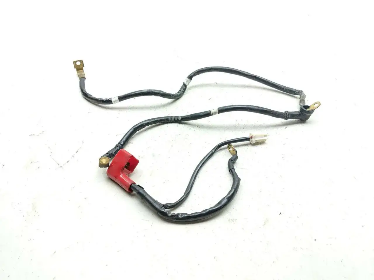 Cableado para conectar batería moto, con terminales y protector rojo.