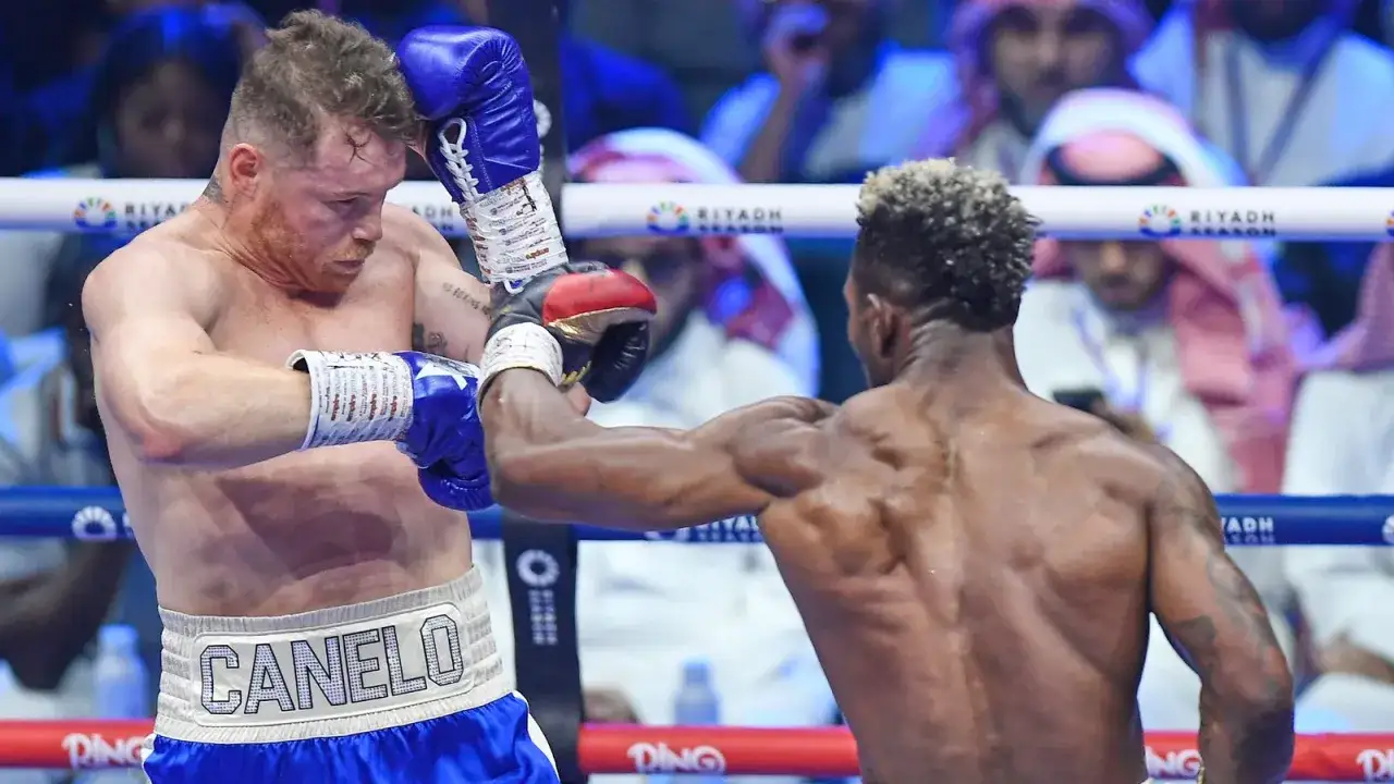 Canelo, with his signature shorts, dodges a punch during a fierce boxing match. His record is on the line.